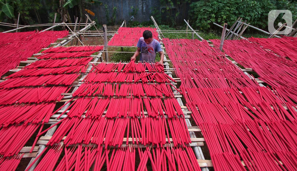 Seorang pekerja menjemur hio dupa di sentra industri kecil pembuatan hio di Tangerang, Banten, Senin (9/1/2023). Jelang perayaan Imlek, pesanan hio dupa mengalami peningkatan untuk kebutuhan sembahyang. (Liputan6.com/Angga Yuniar)