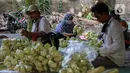 Pedagang musiman membuat kulit ketupat di bawah kolong jembatan kawasan Pesanggrahan, Jakarta, Jumat (8/7/2022). Kulit ketupat untuk perayaan Idul Adha tersebut dijual dengan harga 10ribu hingga 30ribu rupiah. (Liputan6.com/Johan Tallo)