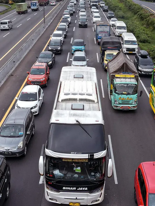 <p>Foto udara memperlihatkan ribuan kendaraan terjebak kemacetan panjang saat menuju kampung halaman untuk merayakan libur panjang Idul Fitri bersama keluarga di jalan bebas hambatan menuju keluar Jakarta di Karawang Timur, Karawang, Jawa Timur, Kamis (28/4/2022). (BAY ISMOYO/AFP)</p>
