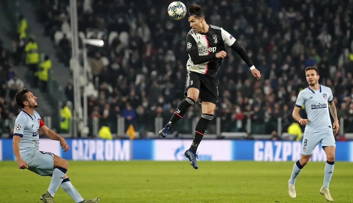Penyerang Juventus, Cristiano Ronaldo menyundul bola dari kawalan pemain Atletico Madrid, Marcos Llorente pada pertandingan Grup D Liga Champions di stadion Allianz di Turin, Italia (26/11/2019). Juventus menang tipis atas Atletico Madrid 1-0. (AP Photo/Antonio Calanni)
