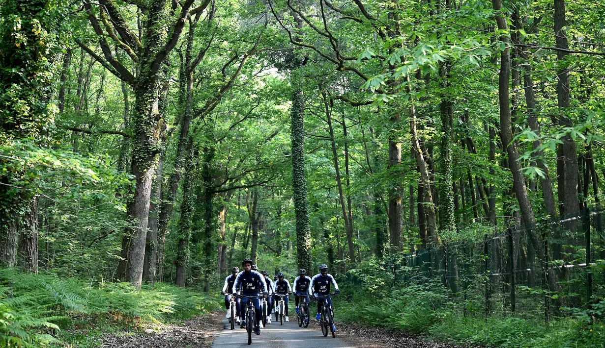 Para pemain Prancis bersepeda di sekitar markas latihan Les Blues di Clairefontaine, Rabu (23/5/2018). Bersepeda merupakan salah satu menu latihan untuk meningkatan kebugaran jelang Piala Dunia 2018. (AFP/Franck Fife)