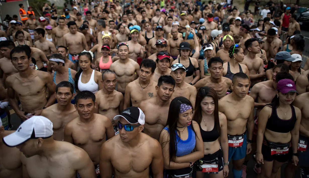 Pelari berbaris di garis start dengan bertelanjang dada ketika berpartisipasi dalam The "Underpants Run" di Manila, Filipina, 8 April 2018. Acara yang pertama kali diadakan di Manila ini berkonsep fun run. (NOEL CELIS / AFP)