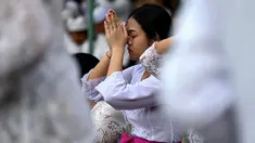 Umat Hindu berkumpul untuk berdoa di sebuah pura merayakan Galungan di Denpasar, Bali, Rabu (2/8/2023). (Photo by SONNY TUMBELAKA / AFP)