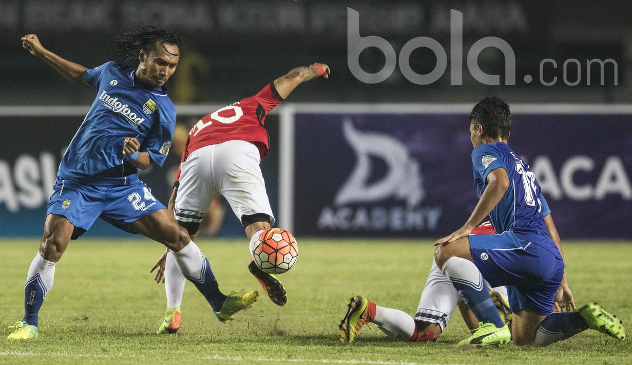 Gelandang Persib Bandung, Hariono, menjatuhkan striker Bali United, Irfan Bachdim. Laga persahabatan ini berlangsung menarik karena kedua klub saling jual beli serangan selama 90 menit. (Bola.com/Vitalis Yogi Trisna)