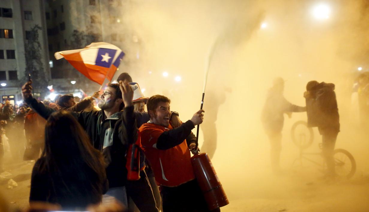 Suporter Cile berpesta di jalanan kota Santiago, Cile, setelah Timnas Cile menang atas Uruguay 1-0 dalam perempatfinal Copa America 2015. (24/6). (REUTERS/Pablo Sanhueza)