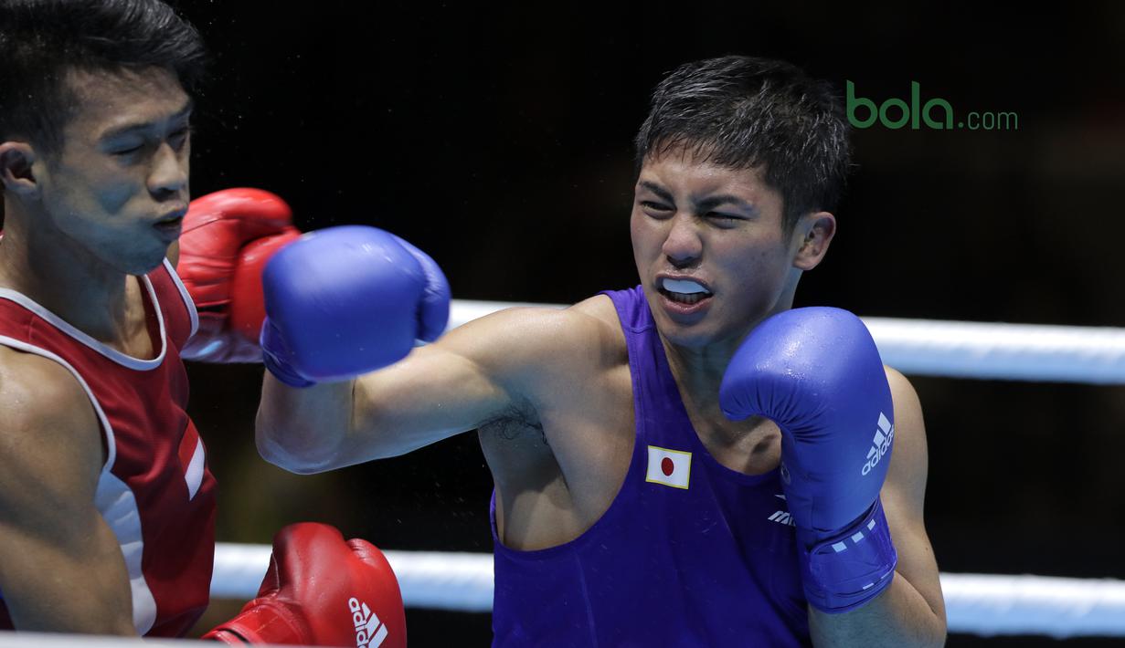 Hiroaki Kinjo melepaskan pukulan ke wajah petinju Indonesia, Grece Savon Simangunsong (Merah) pada semifinal Test Event Asian Games 2018 kelas Welter di Kemayoran, Jakarta (14/2/2018). Simangunsong menang dengan skor 3-2. (Bola.com/Nick Hanoatubun)