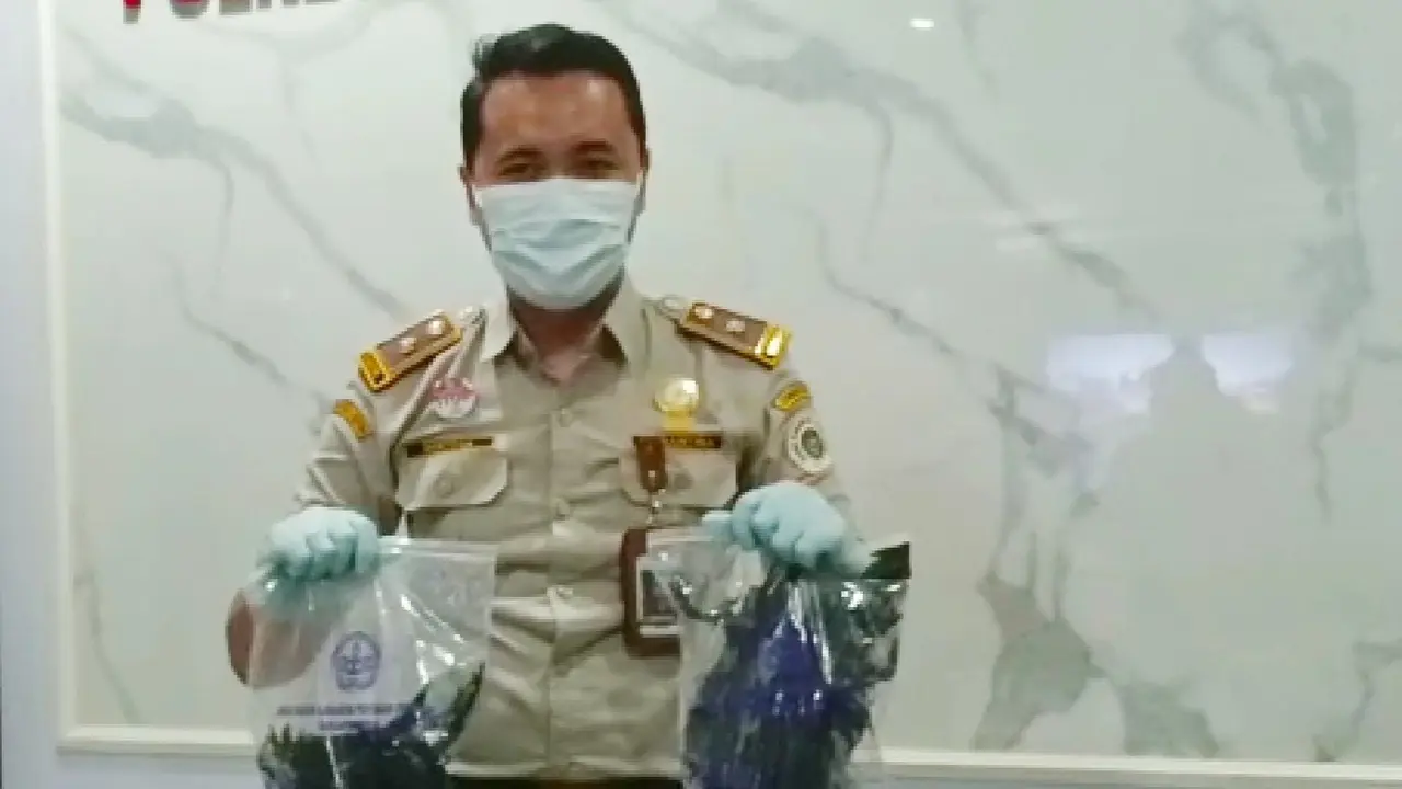 Petugas menunjukkan gagak hitam yang diselundupkan warga Surabaya. (Dian Kurniawan/Liputan6.com)