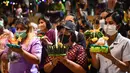 Orang-orang bersiap melepaskan lentera mengambang ke sungai selama festival Loy Krathong di provinsi Narathiwat, Thailand selatan (8/11/2022). Festival ini biasanya berlangsung pada akhir musim hujan ketika bulan purnama menyala di langit pada November. (AFP/Madaree Tohlala)