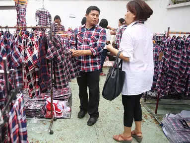 Pedagang menawarkan kemeja kotak-kotak seragam pasangan Ahok-Djarot di Rumah Lembang, Jakarta, Senin (28/11). Para pedagang dengan atribut kampanye pasangan Ahok-Djarot mengais rezeki di tempat tersebut. (Liputan6.com/Immanuel Antonius)