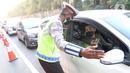 Polisi berbicara dengan pengendara mobil saat penyekatan di KM 31 Tol Jakarta-Cikampek, Kabupaten Bekasi, Jawa Barat, Sabtu (17/7/2021). Penyekatan dilakukan untuk mengantisipasi lonjakan lalu lintas jelang hari libur Idul Adha. (Liputan6.com/Herman Zakharia)