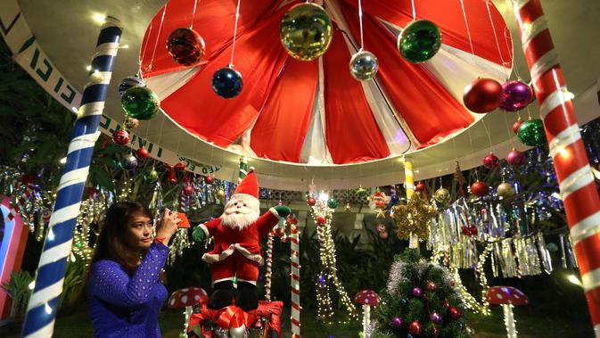 Seorang pengunjung memotret dekorasi Natal dengan telepon seluler di Yangon, Myanmar (10/12/2020). Berbagai dekorasi hingga akseoris dipasang untuk menyambut Natal di kota tersebut. (Xinhua/U Aung)