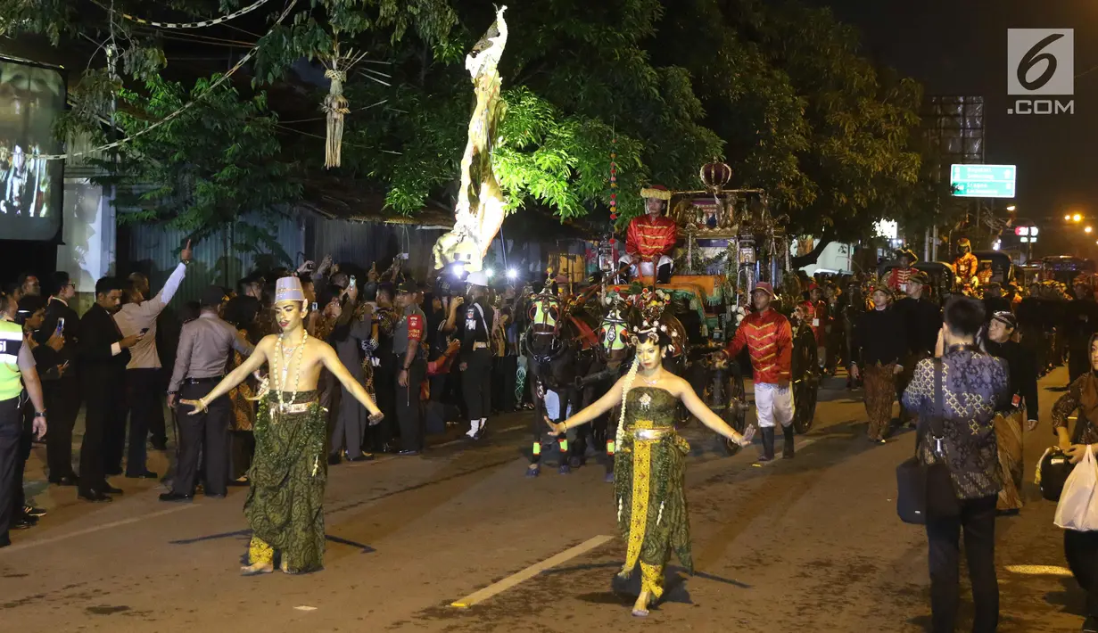 Kereta kencana membawa rombongan pasangan pengantin Kahiyang Ayu dan Bobby Nasution menuju Graha Saba Buana, Solo, Rabu (8/11). Kahiyang dan Bobby menaiki kereta kencana saat resepsi pernikahan malam. (Liputan.com/Angga Yuniar)