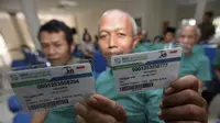 Warga Indonesia sedang melihatkan kartu BPJS Kesehatan