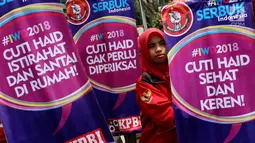 Seorang demonstran Parade Juang Perempuan Indonesia berdiri di samping banner saat demontrasi di depan Gedung DPR, Jakarta, Kamis (8/3). Demonstran meminta pemerintah memperhatikan kesejahteraan dan kemerdekaan perempuan. (Liputan6.com/JohanTallo)