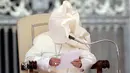 Embusan angin meniup jubah Paus Fransiskus yang sedang memberikan ceramah pada acara audiensi umum di Lapangan Santo Petrus, Vatikan, Rabu (16/5). Tiupan angin tersebut membuat wajah Paus tertutup jubah. (AP Photo/Alessandra Tarantino)