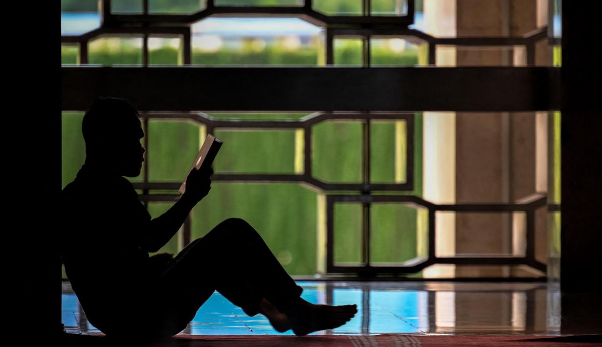 Seorang pria membaca Al-Quran di Masjid Istiqlal, Jakarta pada tanggal 1 Maret 2025. (BAY ISMOYO/AFP)