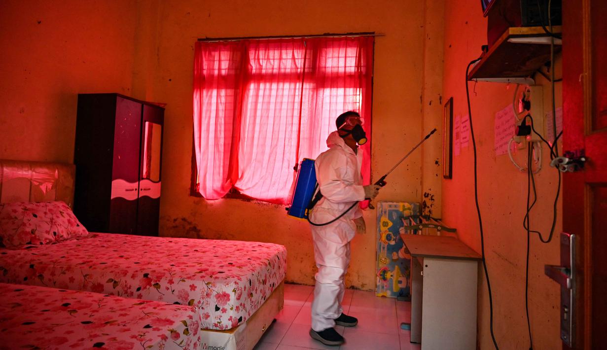 Seorang anggota Badan Penanggulangan Bencana Daerah (BPBD) menyemprotkan disinfektan di sebuah Sekolah Menengah Pertama (SMP) dalam rangka program mitigasi pencegahan penyebaran flu burung di Banda Aceh pada Jumat 31 Oktober 2025. Sebab ruang yang menjadi tempat menginap para siswa tersebut dihuni empat orang per kamar, sehingga lebih rawan terhadap penyebaran penyakit. (Chaideer MAHYUDDIN/AFP)