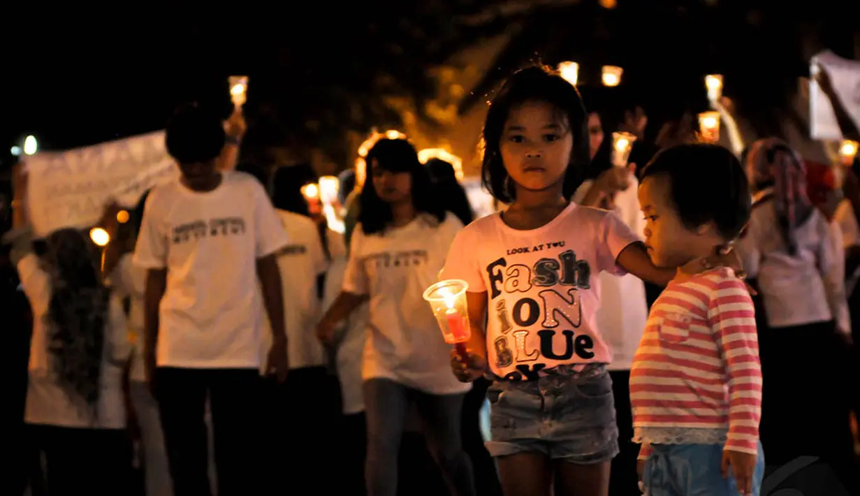 Seorang anak tampak ikut melakukan aksi damai dengan menyalakan lilin di Bundaran HI, Jakarta, Kamis (20/11/2014). (Liputan6.com/Faisal R Syam)