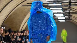 Seorang model memperagakan busana kreasi dari perancang Inggris, Craig Green selama gelaran London Fashion Week Men's di London pada 7 Januari 2019. Craig Green memamerkan pakaian untuk Musim Gugur/Musim Dingin 2019. (NIKLAS HALLE'N/AFP)