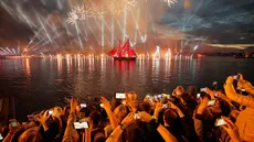 Orang-orang menonton kembang api dan perahu berlayar merah saat White Nights Festival di St.Petersburg, Rusia (24/6). Atraksi terbesar untuk memperingati White Nights adalah Alye Parusa atau Scarlet Sails (Layar Merah). (AP/Dmitri Lovetsky)