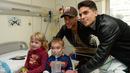 Pemain Barcelona, Marc Bartra (kiri) dan Neymar berpose dengan pasien anak saat melakukan kunjungan amal di Rumah Sakit Vall d' Hebron, Barcelona, Senin (4/1/2016). (AFP PHOTO / Josep LAGO)