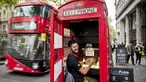 Seorang pria bernama Fouad Choaibi bekerja mereparasi ponsel didalam kotak telepon merah di Southhampton Row, London (20/10). Menjamurnya ponsel, membuat telepon umum di Inggris ini tidak beroperasi lagi. (AFP Photo/Tolga Akmen)