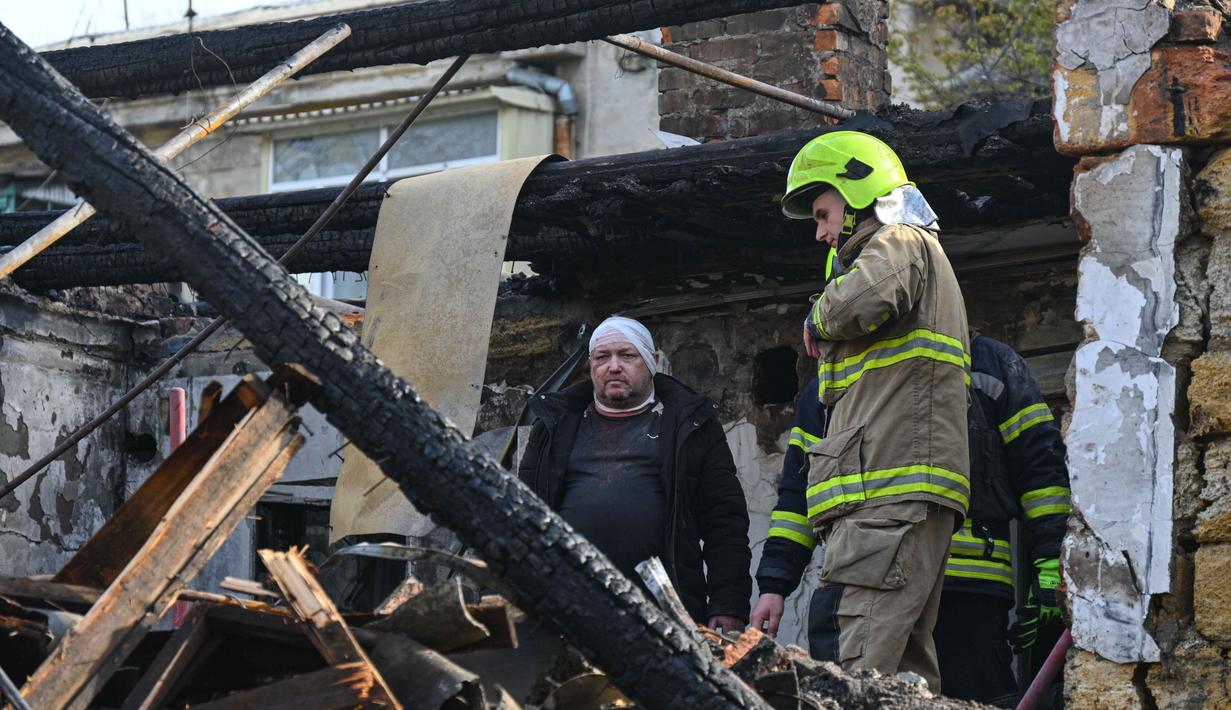 Serangan ini menghancurkan gedung apartemen tiga lantai, sementara bangunan lain mengalami kerusakan parah akibat hantaman pesawat nirawak (drone). Tampak dalam foto, seorang pria yang terluka berdiri di dalam apartemennya di sebuah rumah tinggal yang hancur akibat serangan Rusia di Odesa, Ukraina, Jumat 24 April 2026. (AP Photo/Michael Shtekel)