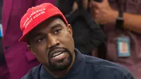 Rapper Kanye West ketika bertemu dengan Presiden AS, Donald Trump di Oval Office, Gedung Putih, Kamis (11/10). West mengenakan topi bertuliskan slogan yang kerap digaungkan Trump, yakni "Make America Great Again". (SAUL LOEB / AFP)