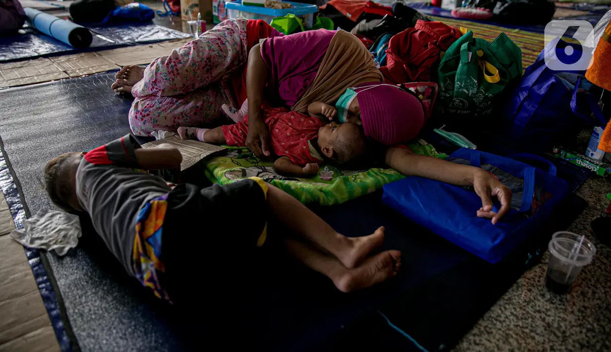 Warga korban banjir Cipinang Melayu beristirahat saat mengungsi di Masjid Universitas Borobudur, Jakarta, Minggu (21/2/2021). Sebanyak 60 orang warga dari RW 04 Kelurahan Cipinang Melayu mengungsi karena permukimannya terendam banjir akibat luapan air Kali Sunter. (Liputan6.com/Faizal Fanani)
