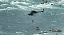 Erendira Wallenda melakukan aksi akrobatik di atas air terjun Niagara, New York, Kamis (15/6). Erendira ditambatkan ke lingkaran besi yang dikaitkan pada helikopter yang terbang 91 meter di atas permukaan air. (Nathan Denette/The Canadian Press via AP)