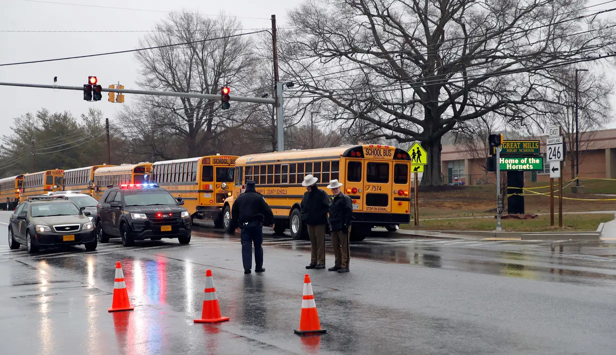 Petugas keamanan setempat berjaga di sekitar lokasi penembakan di Great Mills High School di Maryland, AS (20/3). Korban siswa laki-laki dalam keadaan stabil, sementara siswa perempuan dalam keadaan kritis. (AP Photo / Alex Brandon)