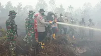 Pemadaman kebakaran lahan di perbatasan Kota Dumai dengan Bengkalis oleh Polda Riau serta instansi terkait. (Liputan6.com/M Syukur)