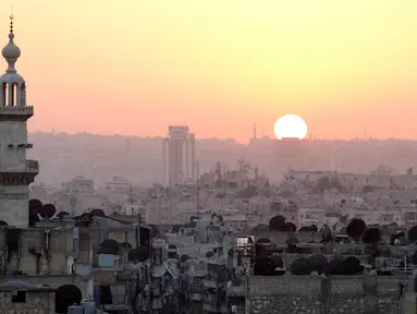  Matahari terbenam di kawasan yanag dikuasai pemberontak di Alepo, Suriah (5/10). PBB mengatakan banyak kerusakan baru yang mungkin disebabkan oleh serangan udara yang dilakukan pasukan pro-pemerintah Suriah. (REUTERS/Abdalrhman Ismail)
