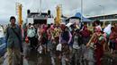 Para pengungsi turun dari kapal ferry usai dievakuasi dari Pulau Sebesi, di Pelabuhan Bakauheni, Lampung, Rabu (26/12). Ribuan pengungsi tsunami dari Pula Sebesi terpaksa dievakuasi menggunakan kapal ferry. (AFP Photo/Mohd Rasfan)