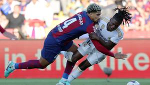 Bek Barcelona, Ronald Araujo melanggara gelandang Real Madrid, Eduardo Camavinga dalam laga El Clasico di La Liga 2023/2024. (AFP/Lluis Gene)