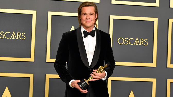 Brad Pitt berpose di ruangan pers seusai menerima piala Oscar dalam ajang Academy Awards ke-92 di Dolby Theatre, Los Angeles, Minggu (9/2/2020). Brad Pitt menyabet penghargaan sebagai Aktor Pendukung Terbaik untuk aktingnya di film Once Upon a Time in Hollywood. (Amy Sussman/Getty Images/AFP)