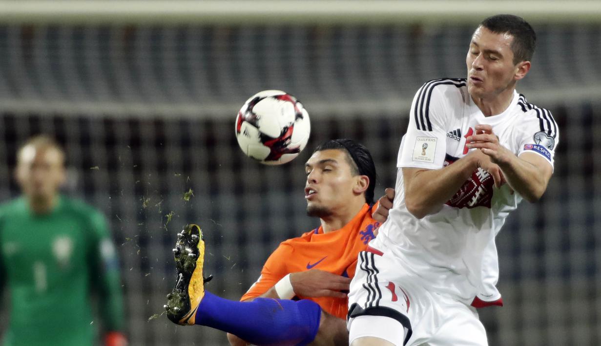 Bek Belanda, Karim Rekik, berebut bola dengan striker Belarusia, Nikolai Signevich, pada laga kualifikasi Piala Dunia 2018 di Stadion Borisov Arena, Borisov, Sabtu (7/10/2017). Belarusia kalah 1-3 dari Belanda. (AP/Sergei Grits)