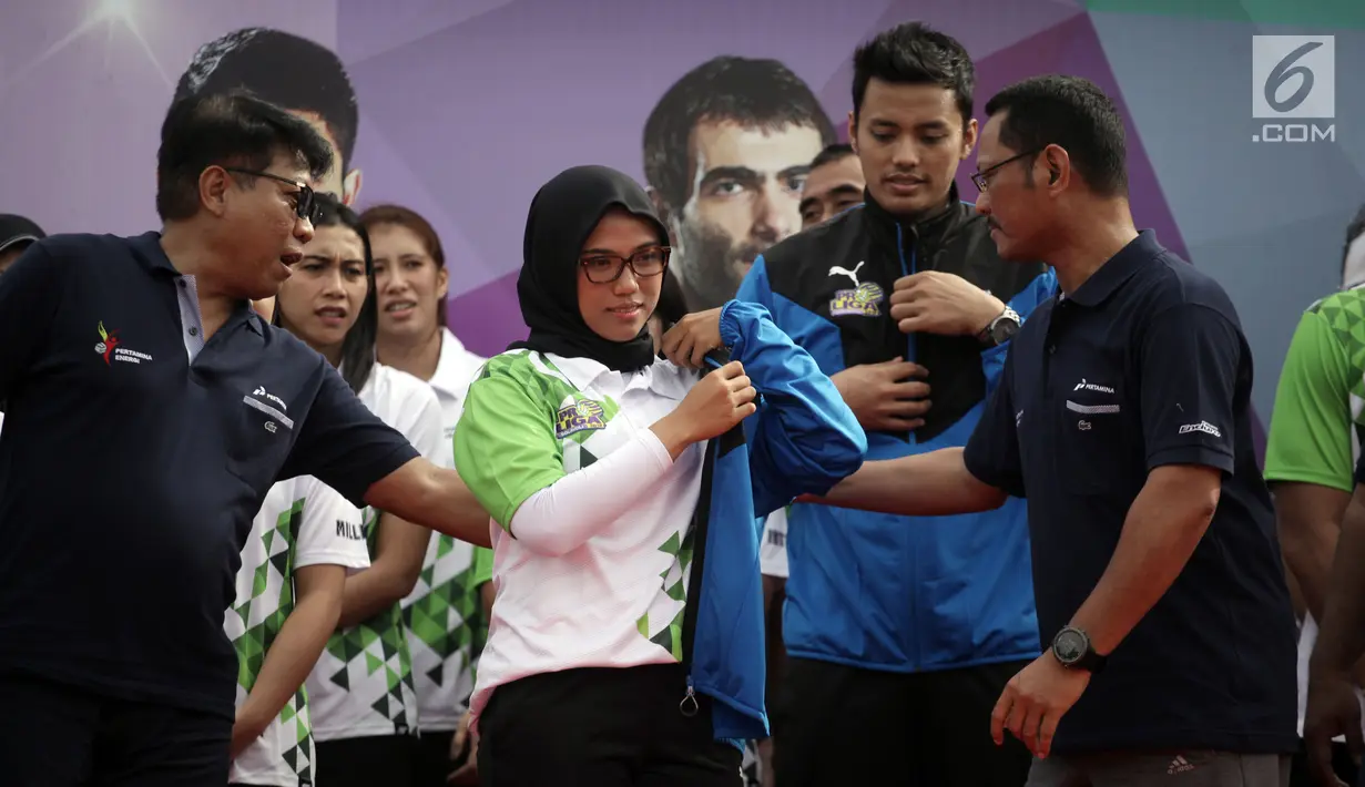 Direktur Manajemen Aset Pertamina Dwi Wahyu Daryoto mengenakan jaket kepada pemain putri saat Launching Tim Bola Voli Jakarta Pertamina Energi di Kantor Pusat Pertamina, Jakarta, Jumat (5/1).(Liputan6.com/Arya Manggala)