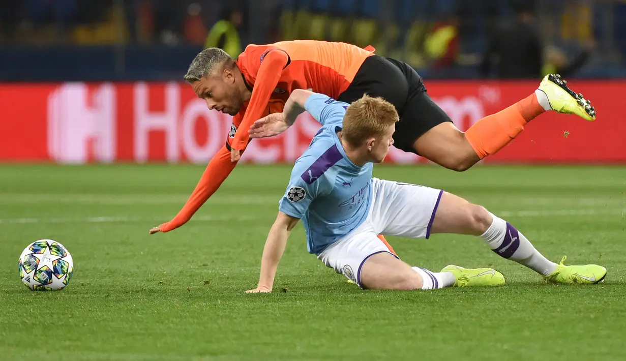 Gelandang Manchester City, Kevin De Bruyne dan pemain Shakhtar Donetsk Marlos terjatuh saat berebut bola pada laga pertama Grup C Liga Champions di Metalist Stadium, Rabu (18/9/2019). Manchester City sukses menghantam Shakhtar Donetsk dengan skor 3-0. (Genya SAVILOV / AFP)