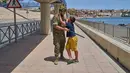 Seorang anak berusia 12 tahun yang menyeberang ke Spanyol tanpa didampingi orang dewasa dikawal oleh seorang tentara Spanyol ke perbatasan Spanyol-Maroko sementara anak itu memohon agar tidak dikirim kembali ke Maroko dari wilayah kantong Spanyol di Ceuta, Senin, 3 Agustus 2026. (Foto AP/Bernat Armangue)