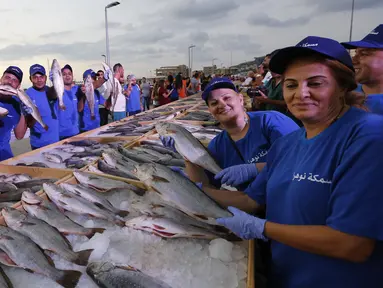 Anggota dari Lebanon's Batroun Traders Association memegang ikan yang berhasil memecahkan rekor makanan laut terbanyak di daerah kota pantai Batroun, Minggu (4/9). Menurut panitia, total ikan yang dikumpulnya sebanyak 2 ton 614 kg. (AFP PHOTO/Anwar AMRO)