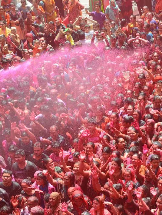 Umat Hindu India disemprot dengan cairan berwarna dalam festival keagamaan Holi di Kuil Swupramayan Kalupur, Ahmedabad, Rabu (20/3). Holi merupakan festival Hindu terbesar di India yang menandai dimulainya musim semi. (SAM PANTHAKY / AFP)