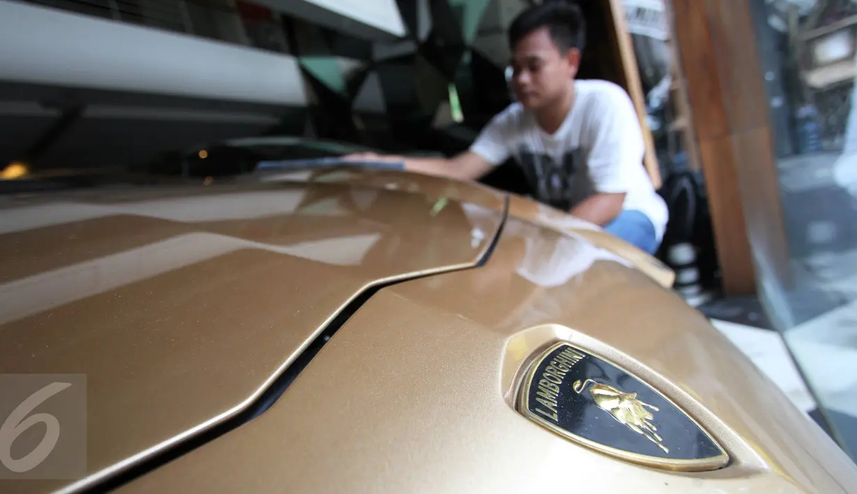 Petugas membersihkan mobil Lamborghini Aventador LP 700-4 tahun 2013 di Auto One Cars Boutique, Jakarta, Senin (5/10/2015). Mobil sport mewah tersebut akan dilelang DJKN Kemenkeu dengan nilai limit Rp 8,26 miliar. (Liputan6.com/Immanuel Antonius)
