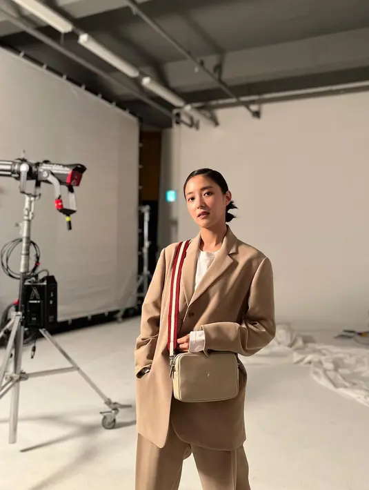 Tampil dengan chic, Lee Se Young mengenakan set blazer dengan berwarna beige. Dipadukan dengan t-shirt putih dan sling bag berwarna nude. (instagram/seyoung_10)