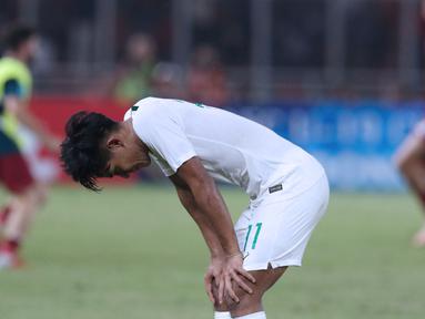 Pemain Timnas Indonesia U-19, Firza Andika tertunduk usai melawan Qatar U-19 pada penyisihan Grup A Piala AFC U-19 2018 di Stadion GBK, Jakarta, Minggu (21/10). Indonesia kalah tipis 5-6. (Liputan6.com/Helmi Fithriansyah)