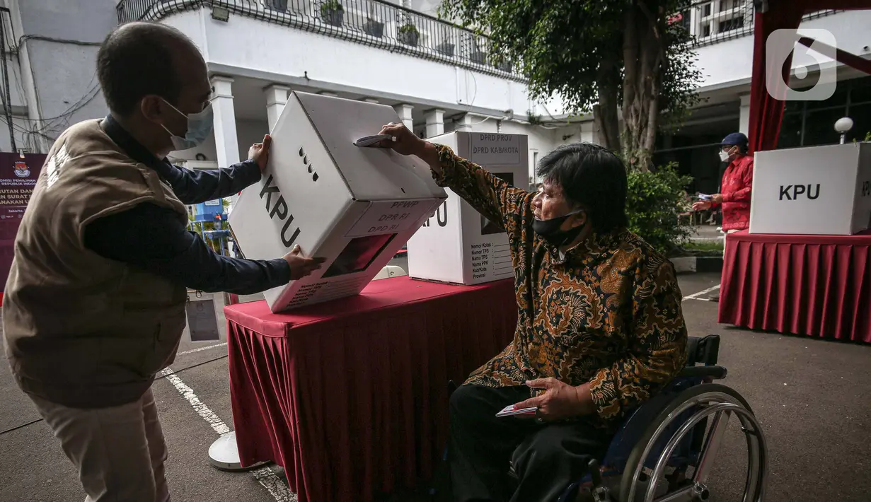Penyandang disabilitas memasukkan surat suara saat simulasi Pemilu 2024 di Kantor KPU RI, Jakarta, Selasa (22/3/2022). Simulasi digelar untuk memberikan edukasi kepada masyarakat terkait proses pemungutan dan penghitungan suara pemilu serentak tahun 2024. (Liputan6.com/Faizal Fanani)