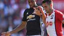 Striker Manchester United, Marcus Rashford, berebut bola dengan gelandang Southampton, Dusan Tadic, pada laga Premier League di Stadion St Mary's, Sabtu (23/9/2017). Manchester United menang 1-0 atas Southampton. (AFP/Glyn Kirk)