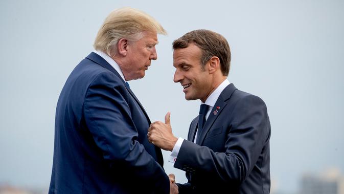 Presiden Prancis Emmanuel Macron (kanan) menyambut kedatangan Presiden AS Donald Trump (kiri) di KTT G7, Biarritz, Prancis, Sabtu (24/8/2019). G7 adalah sebuah grup yang terdiri dari Kanada, Prancis, Jerman, Italia, Jepang, Britania Raya, dan Amerika Serikat. (AP Photo/Andrew Harnik)