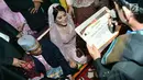 Putri Presiden Joko Widodo, Kahiyang Ayu dan Muhammad Bobby Afif Nasution menerima sertifikat  dalam prosesi Mangalehan Marga, Boru Siregar, di rumah paman Bobby di Medan, Selasa (21/11). (Liputan6.com/Pool/Media Center)