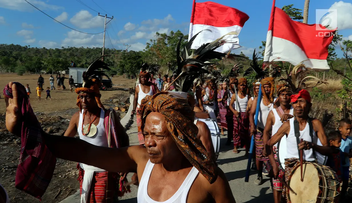 Warga Desa Oebelo menggelar upacara penyambutan saat peresmian bantuan bedah rumah  di Desa Oebelo, Kupang, NTT, Selasa (14/8). Upacara penyambutan diwarnai dengan tarian-tarian menggunakan alat musik baba khas daerah itu. (Liputan6.com/Johan Tallo)